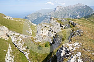 Scenic view of a sharp high cliff, rocks, green hillsides, mountain peaks in North Osetia Russia photo